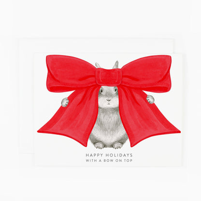 A card featuring a graphite bunny with a big red bow on its head and text underneath that reads &quot;Happy holidays with a bow on top&quot;.