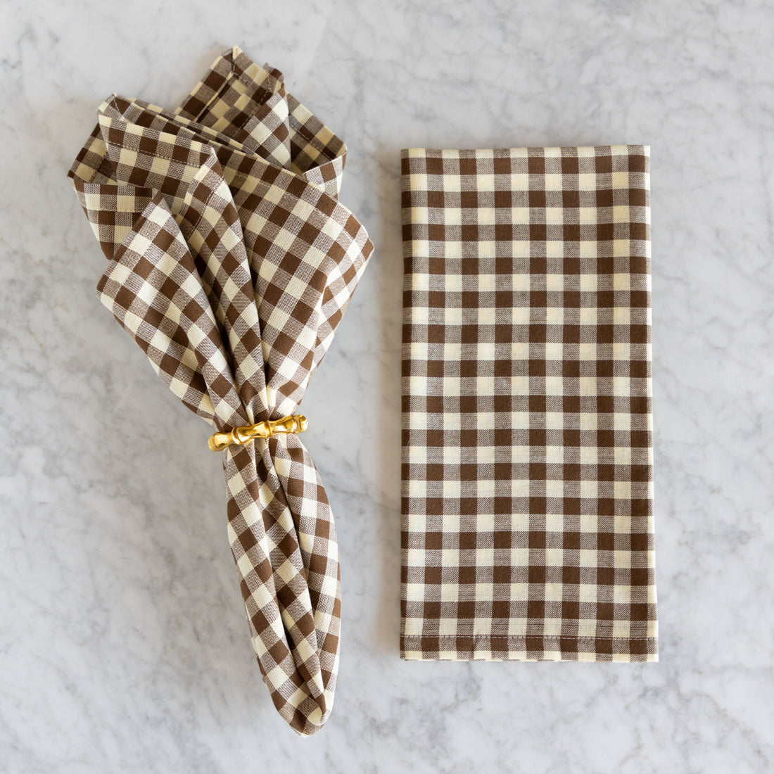 Brown and white checkered napkin on a marble surface.
