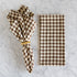 Brown and white checkered napkin on a marble surface.