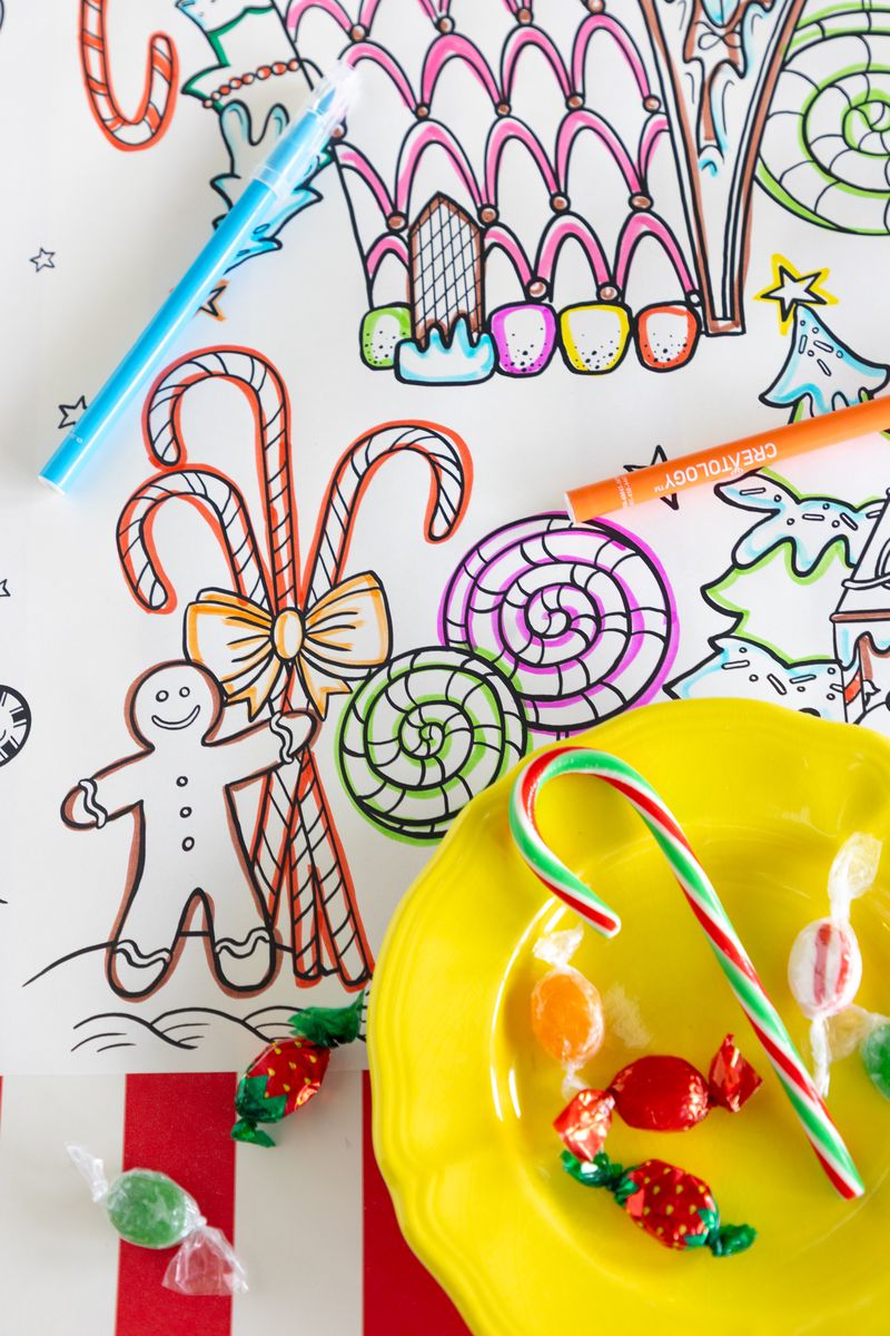 A close-up of an illustration on a paper coloring runner, showing a ginger bread man holding a candy cane. 