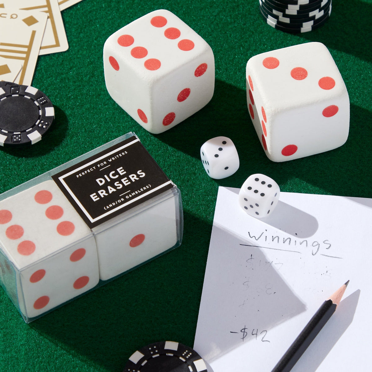 Dice erasers on game table with pencil and real dice