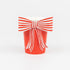 A red paper cup by Meri Meri with a white and red striped paper bow on it.