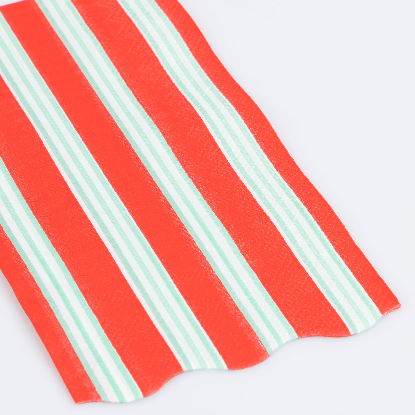 Red and green striped paper napkin on a white background.