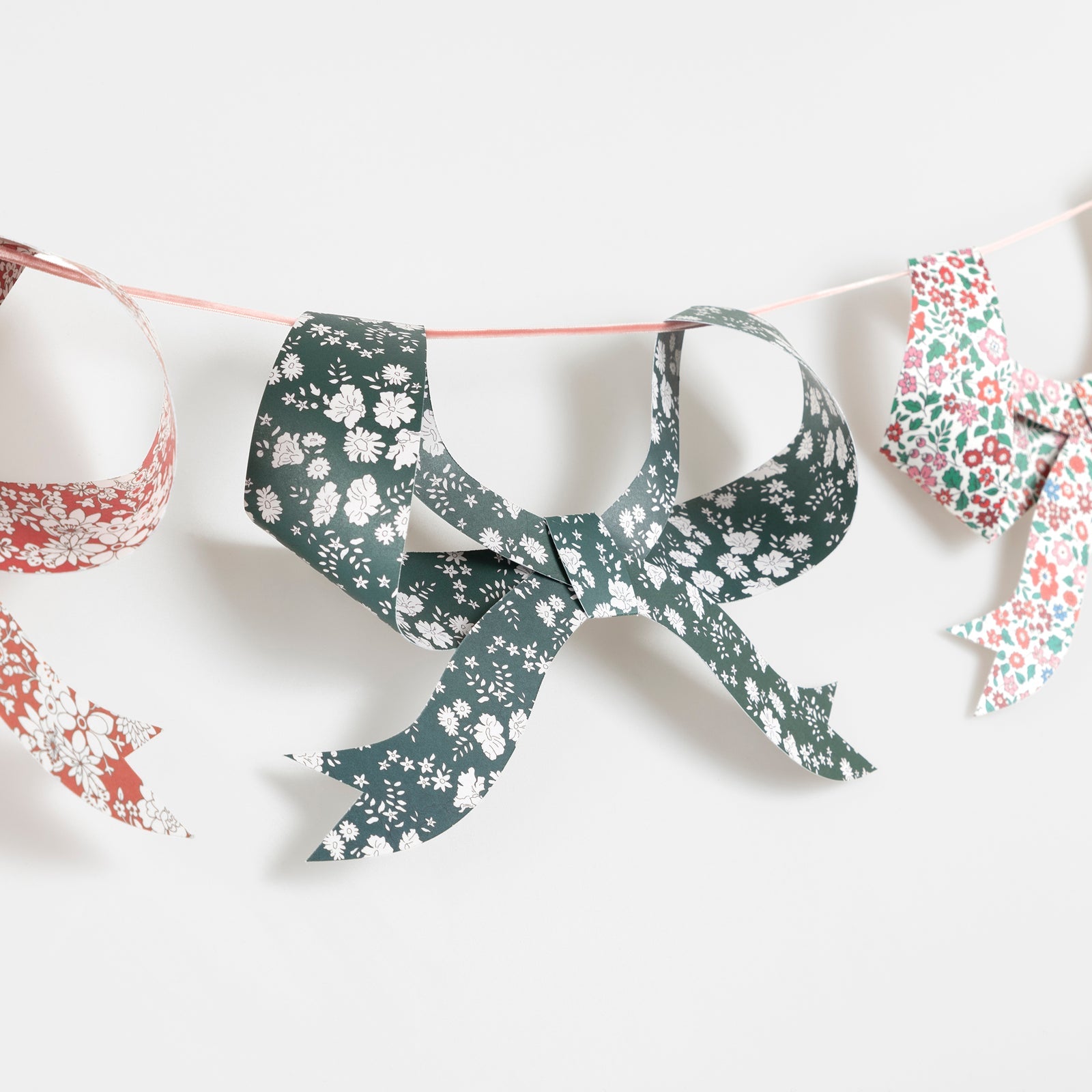 Decorative garland with Liberty of London printed bows on a white background.