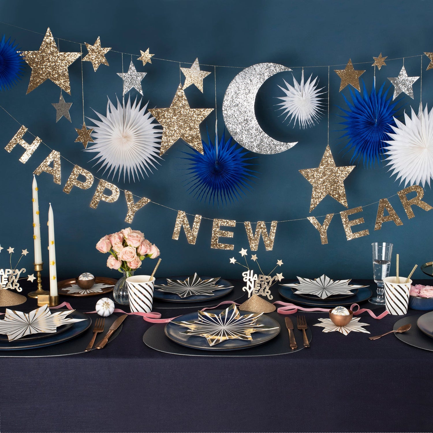 A festive Celestial New Year Garland comprising a banner with the words &quot;happy New Year&quot; in gold lettering, flanked by blue and silver paper fans and gold and silver stars by Meri Meri.