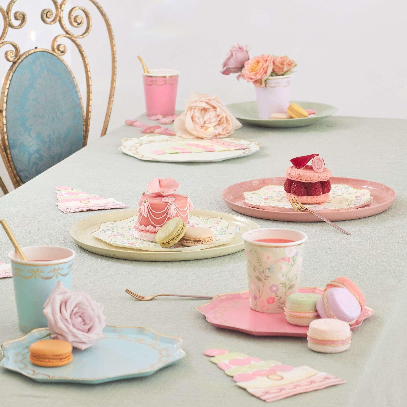 A table full of plates, cups, and Meri Meri Ladurée Paris Macaron Surprise Balls.