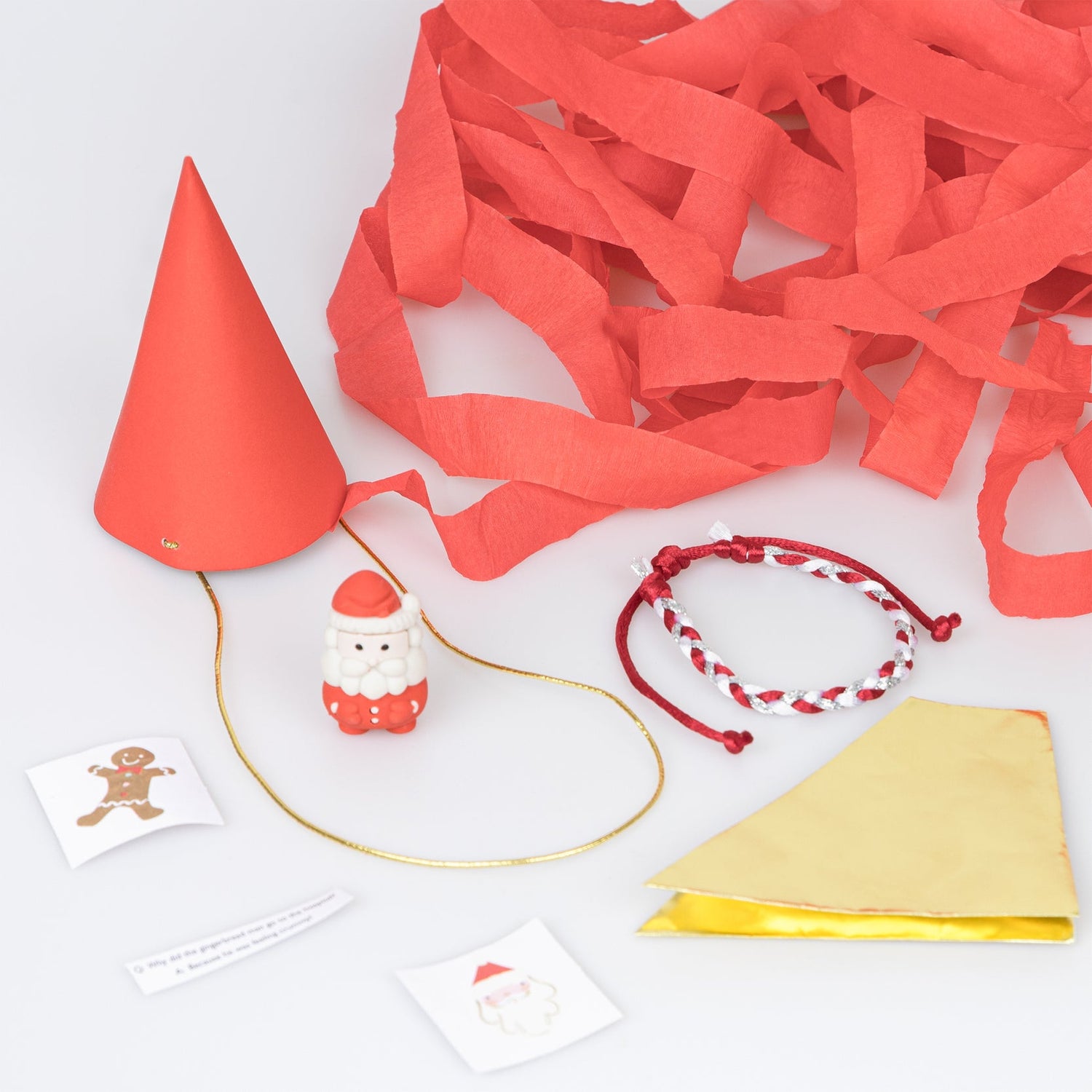 a gold foil party hat, a joke, a Santa eraser, 2 stickers (one with foil), and a red/white/gold friendship bracelet