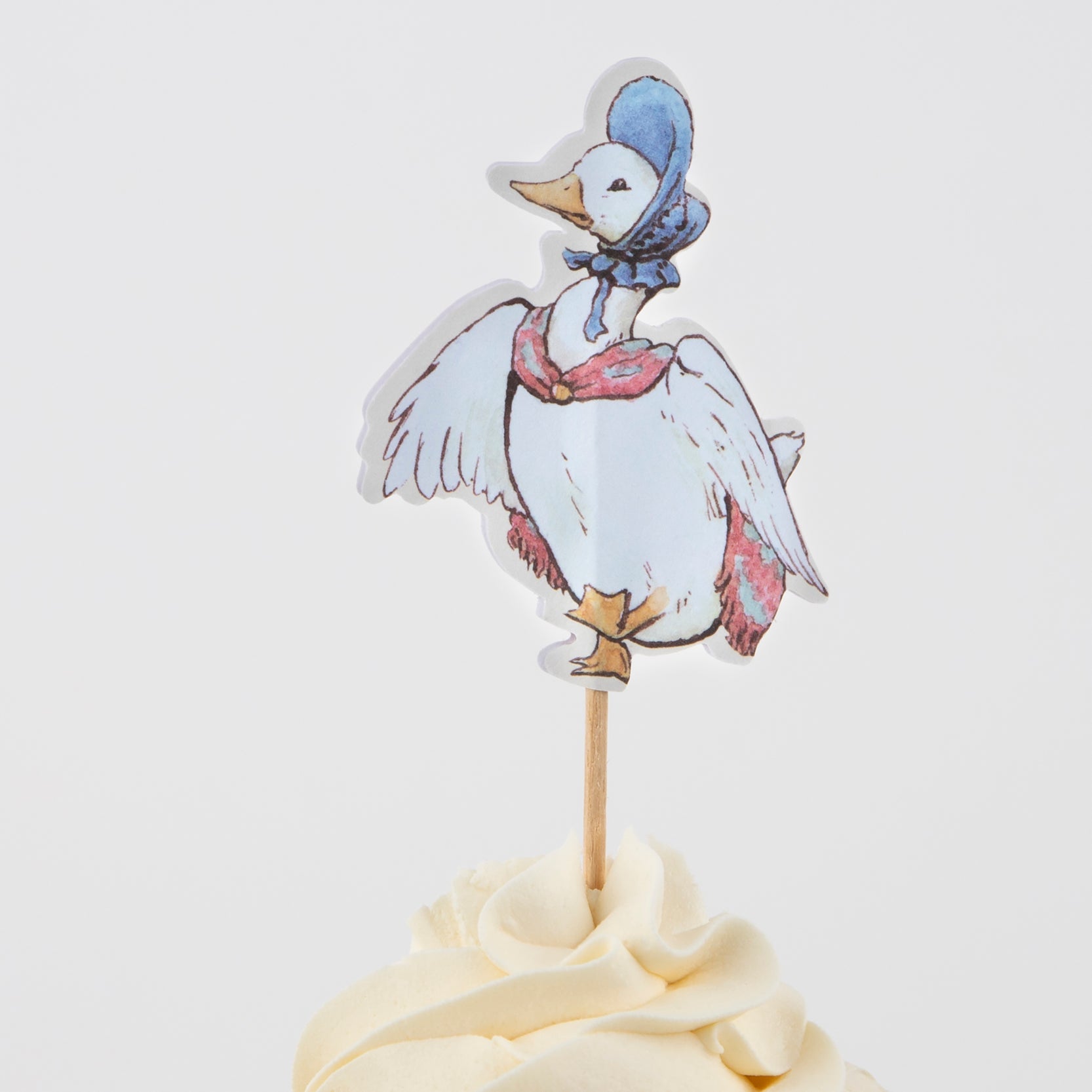 A cupcake with an image of a duck on top, decorated using Peter Rabbit™ In The Garden Cupcake Kit from Meri Meri.