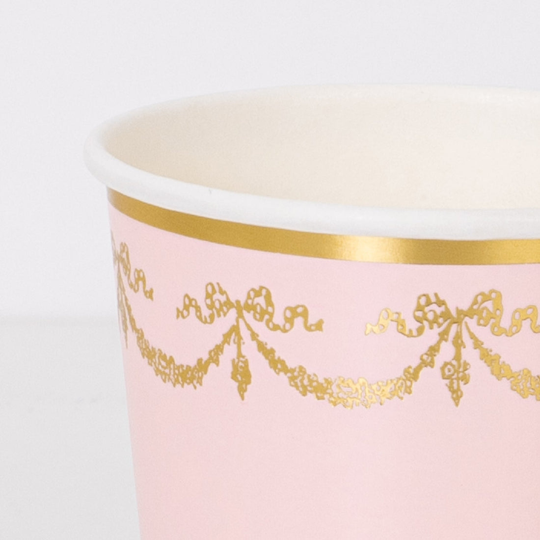A pink Meri Meri Ladurée Paris cup with gold trim.