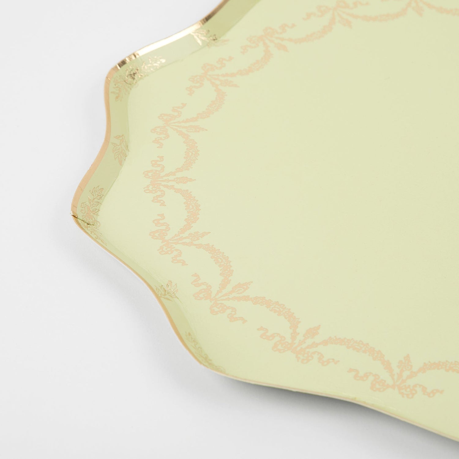 A green serving tray with gold trim and Meri Meri Ladurée Paris Paper Plates.