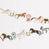 A decorative Meri Meri Horse Garland featuring an enchanting arrangement of horses accented with ribbons.