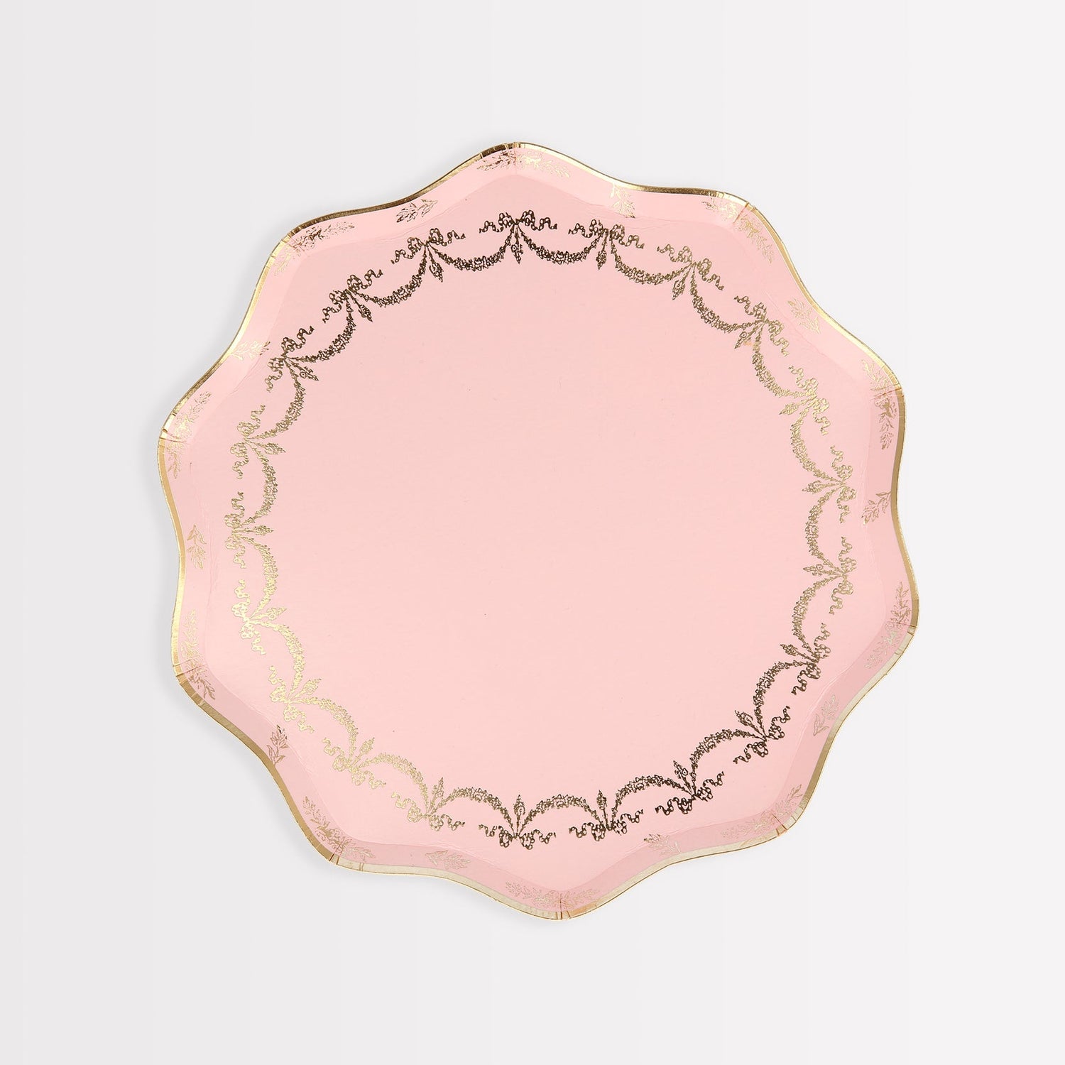 A pink Ladurée Paris paper plate with gold trim, perfect for serving delicate desserts like macarons.