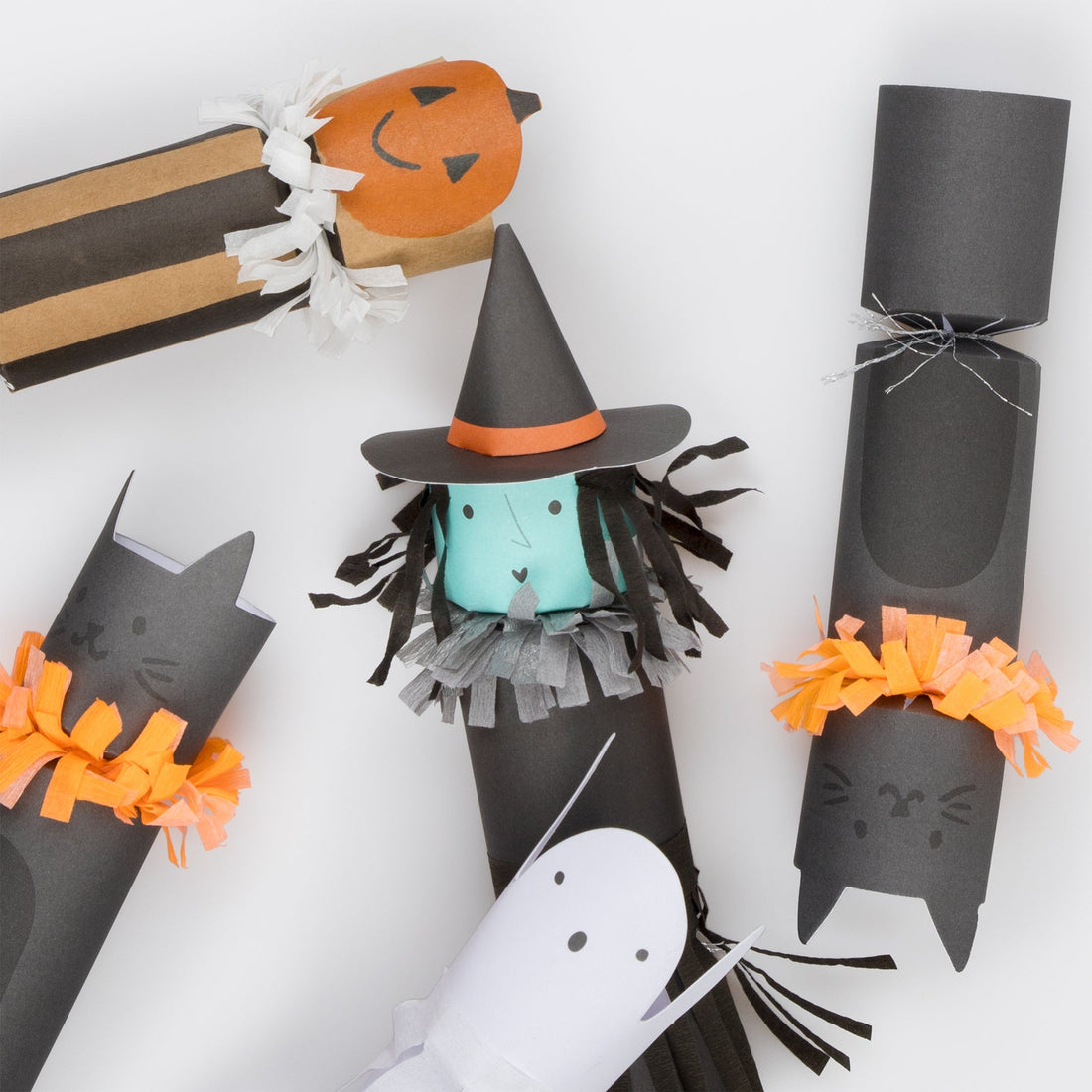 Four styles of Halloween crackers; a pumpkin, a witch, a cat, and a ghost