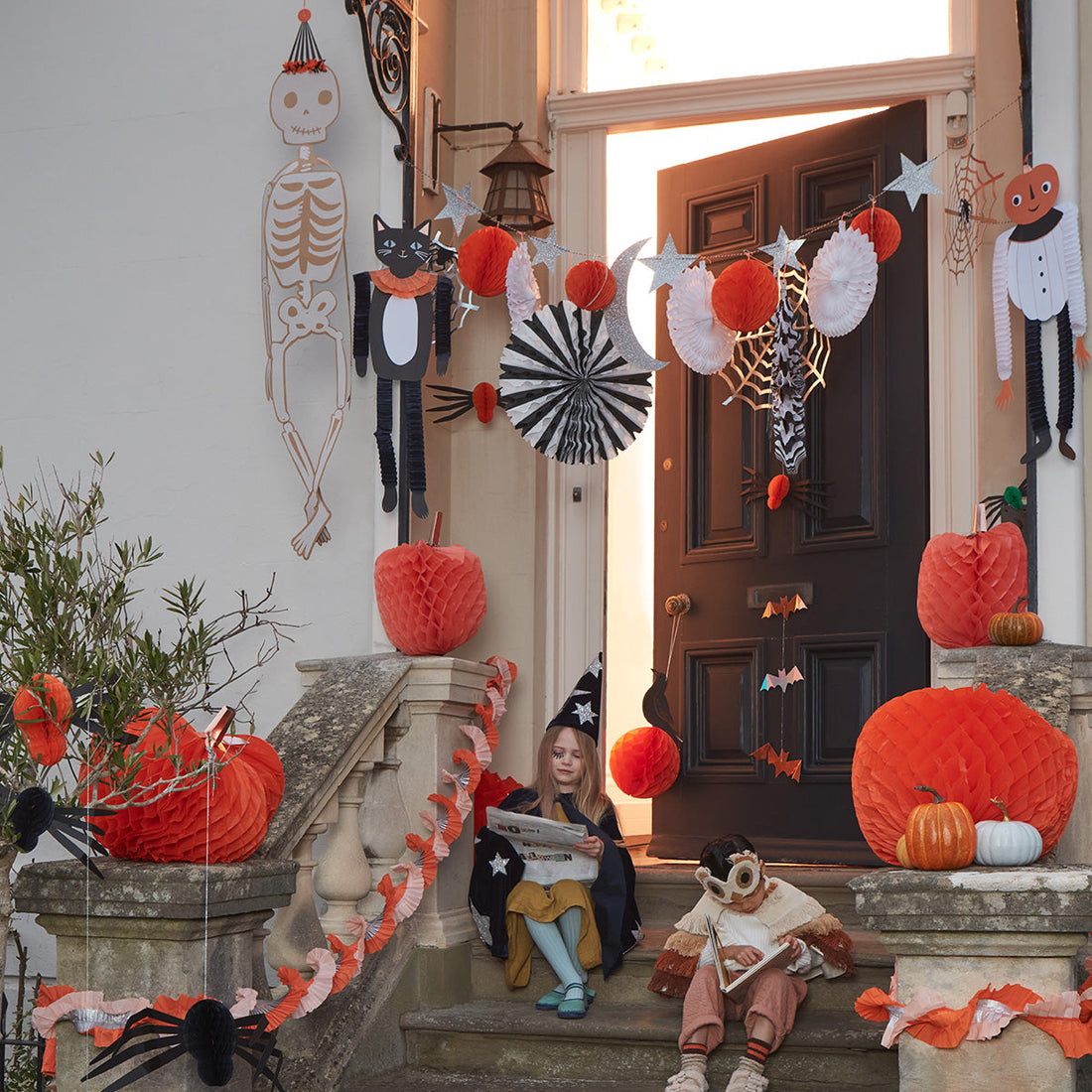 a home front steps decorated for Halloween featuring the Halloween Honeycomb Shapes Garland