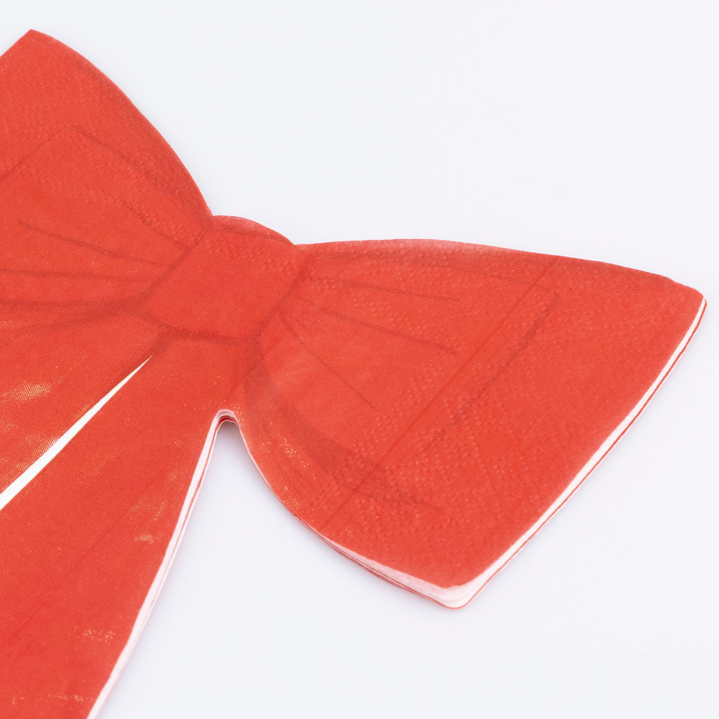 Red bow-shaped paper napkin on a white background.