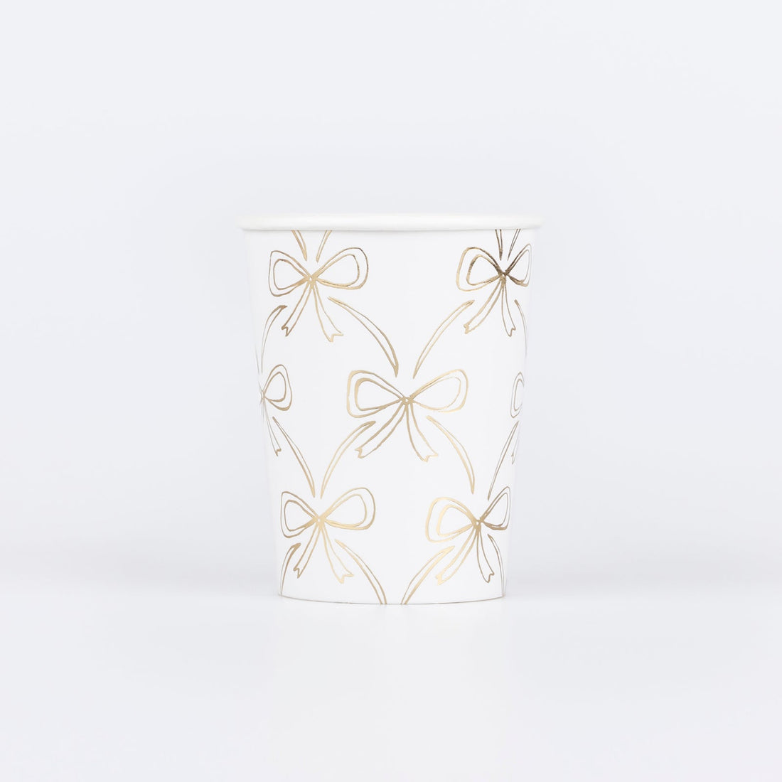 Paper cup by Meri Meri with illustrations of gold bows. 