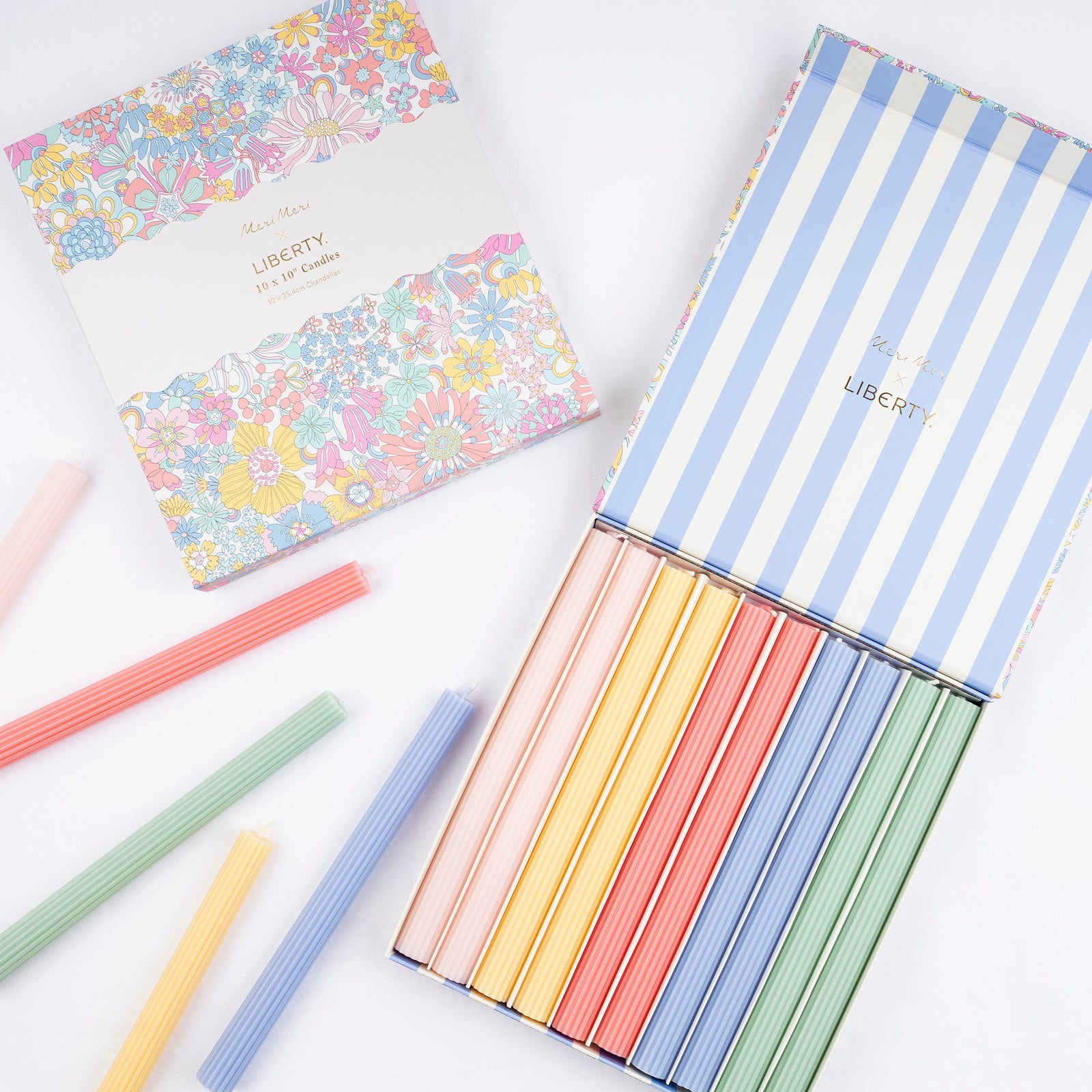 Meri Meri x Liberty Rainbow Garden Candle Gift Box with colorful tapers inside, scattered candles on the table and a colorful floral pattern on the outside.