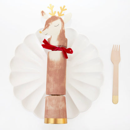 The Reindeer Christmas Character Cracker resting on a white plate with a fork beside it.