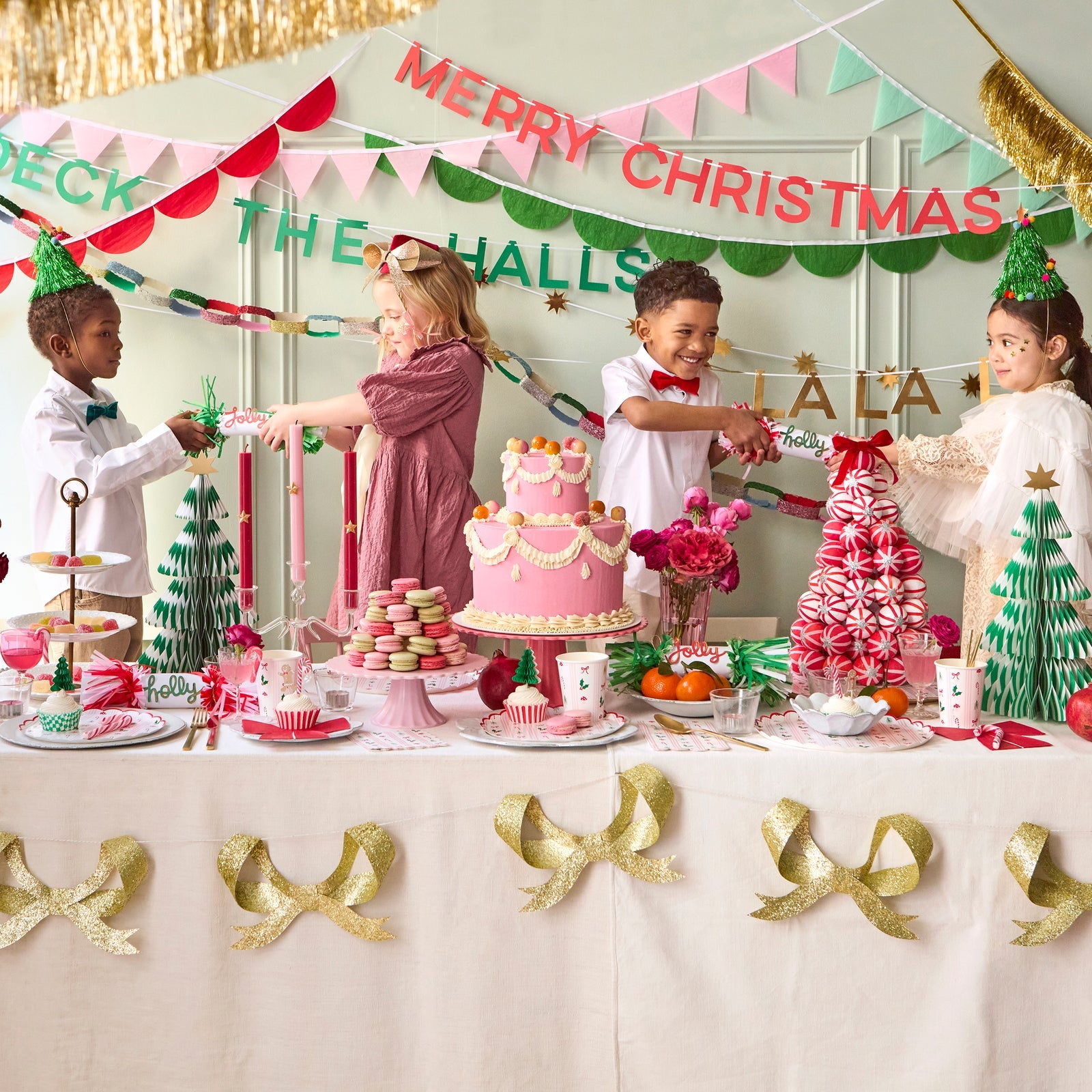 Children at a Christmas-themed party with a cake and decorations.