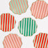 Hexagonal cookies with red, green, and pink striped patterns on a white background