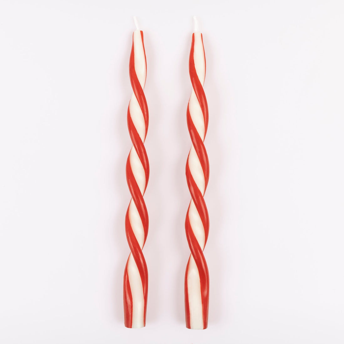 Two red and white striped candles on a light gray background.