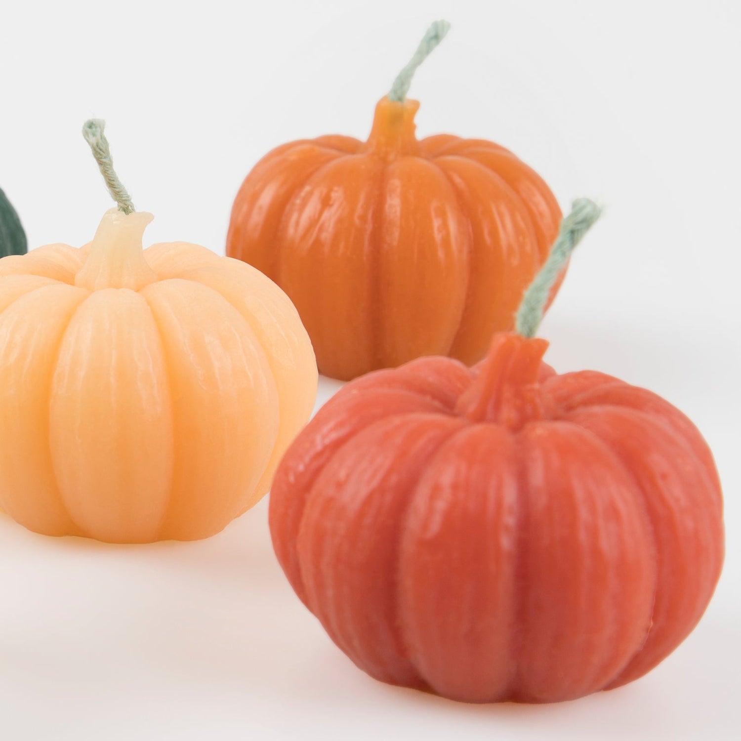 Pumpkin-shaped candles in multiple colors. 