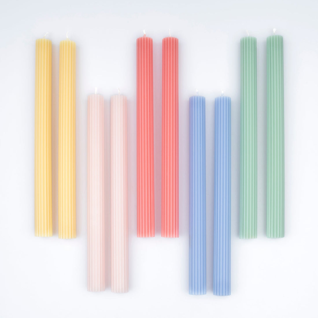 Set of colorful candles arranged in a row on a white background.