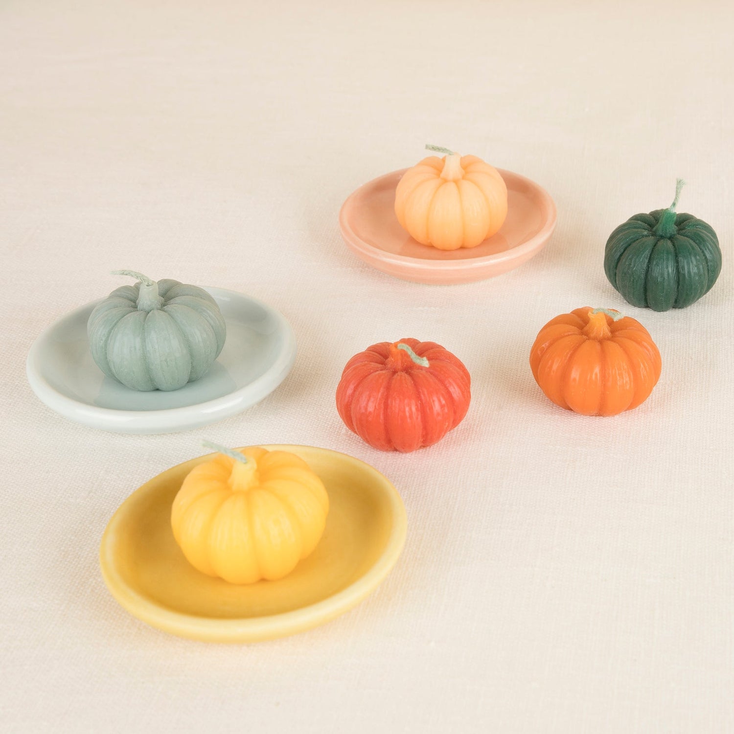 Pumpkin-shaped candles in multiple colors. 