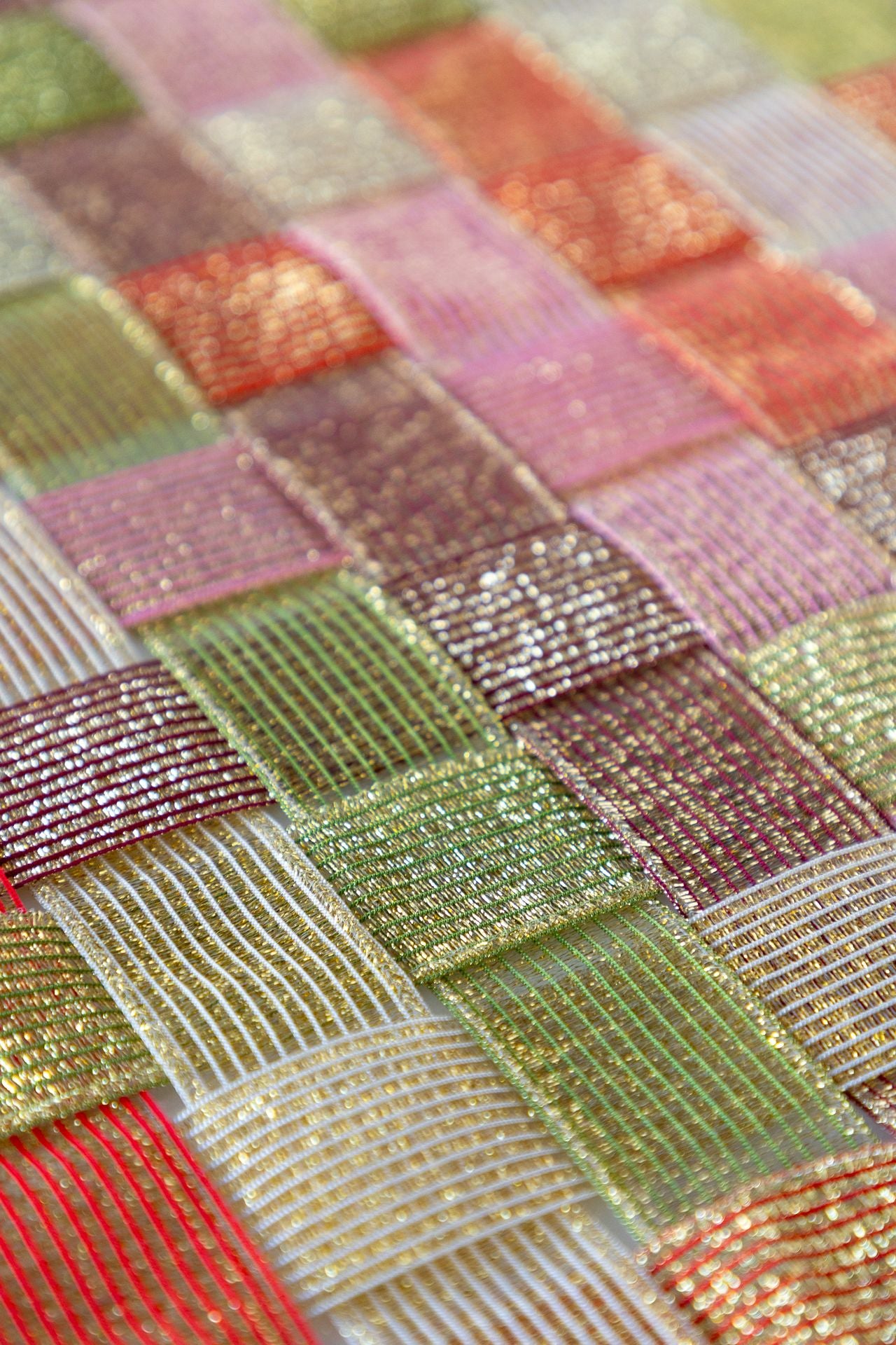 A surface woven with sparkle ribbon in five different colors.
