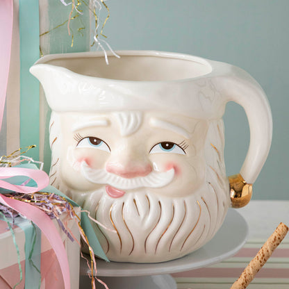 A close up of the Papa Noel Pitcher showing its jolly facial expression, rosy cheeks and nose, and gold intricate detailing.