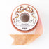 Spool of pink and gold sparkle ribbon by Hester & Cook on a white background