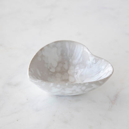 A small Stoneware Heart Dish by Creative Co-Op on a marble table.