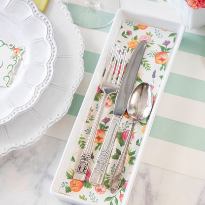 Close-up of a flatware tray lined with a cut-out rectangle of the Sweet Garden Placemat, used in an elegant springtime place setting.