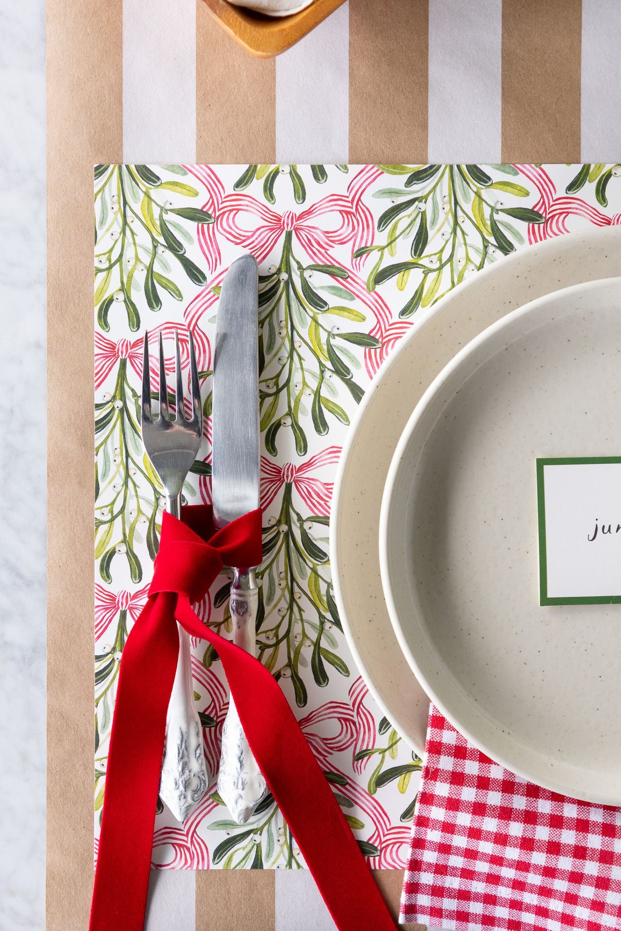 A holiday place setting with the fork and knife tied with soft red ribbon.