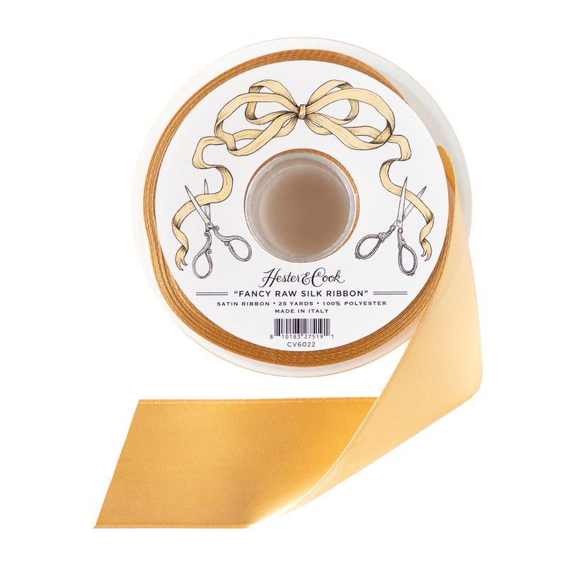 A spool of cream colored satin ribbon by Hester &amp; Cook on a white background.