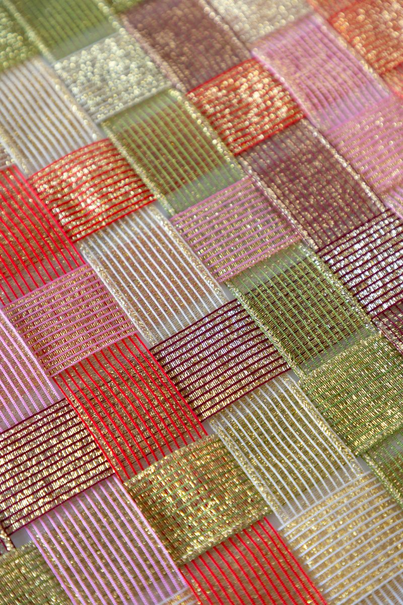 A surface woven with sparkle ribbon in five different colors.
