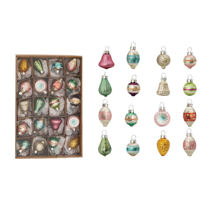 A box of assorted vintage inspired pastel ornaments in a box and out of the box, on a white background.