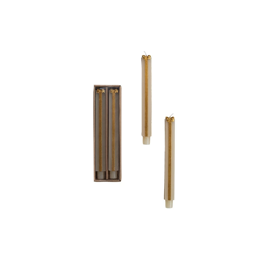 Two Tall Unscented Cream &amp; Gold Present Shaped Taper Candles packaged in a brown box and two on a white background.