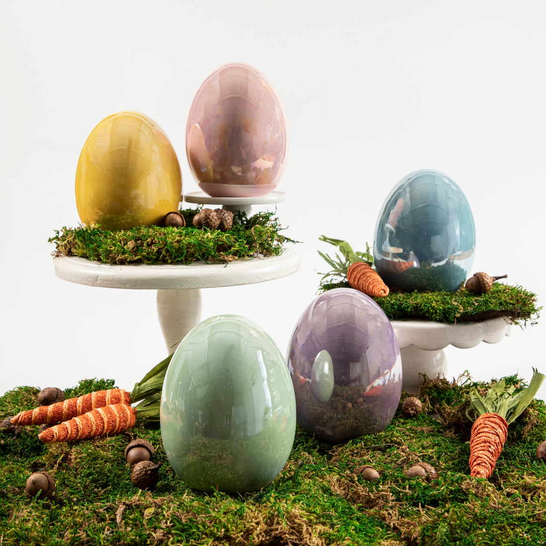Four Glitterville Large Iridescent Eggs, rest atop a moss-covered pedestal.