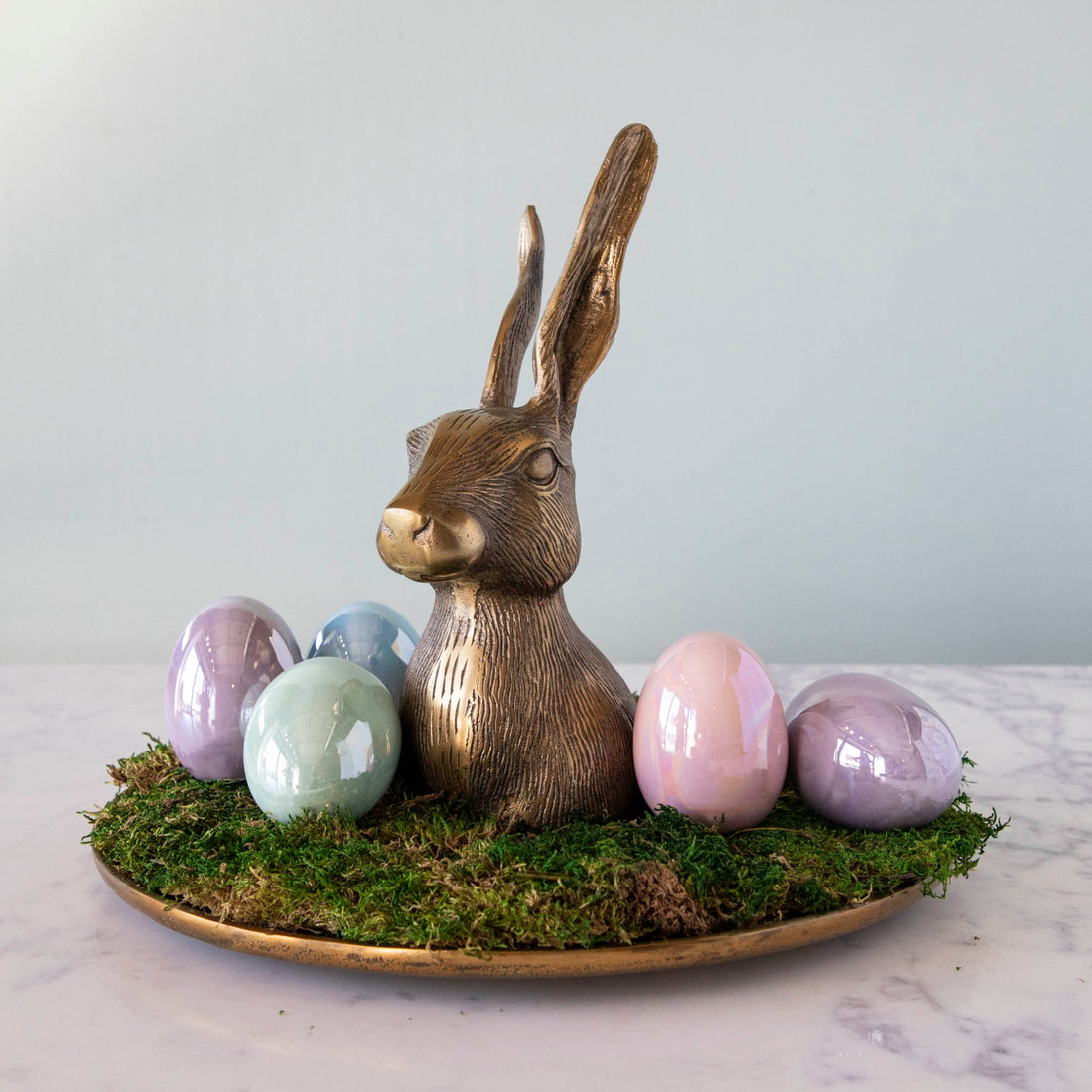 A Hare Platter by Accent Decor sits on top of a whimsy covered table.