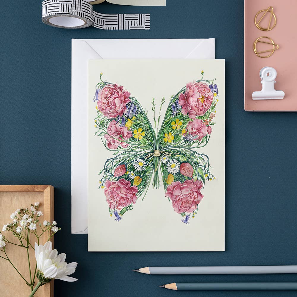 Artistic Butterfly Card created with floral patterns on a cream-colored high-quality card, accompanied by drawing materials on a dark surface by The DM Collection.