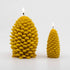 Two Beeswax Pine Cone Candles, one small and one large, both lit.