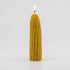 A lit pillar candle shaped like a corn cob. 
