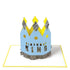 Blue Birthday King Crown Card with "happy birthday king" text and silver crepe paper accents on a white background, by Meri Meri.
