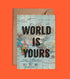 A vintage world map with the phrase "world is yours" superimposed, placed against an orange backdrop with a corner tucked into a brown notebook cover made of recycled paper to create the We Act Company World is Yours Card.