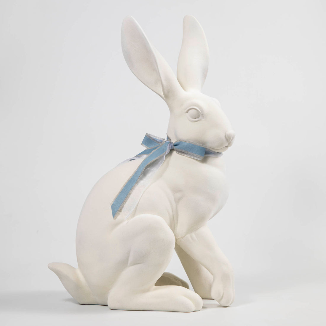 A Flocked Bunny, White &amp; Pink from Glitterville, with a blue ribbon, perfect for Easter decorations.