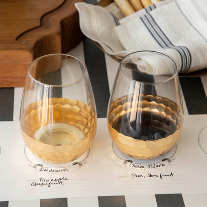 A table setting with Vitorrio Stemless Glassware plates, and napkins.