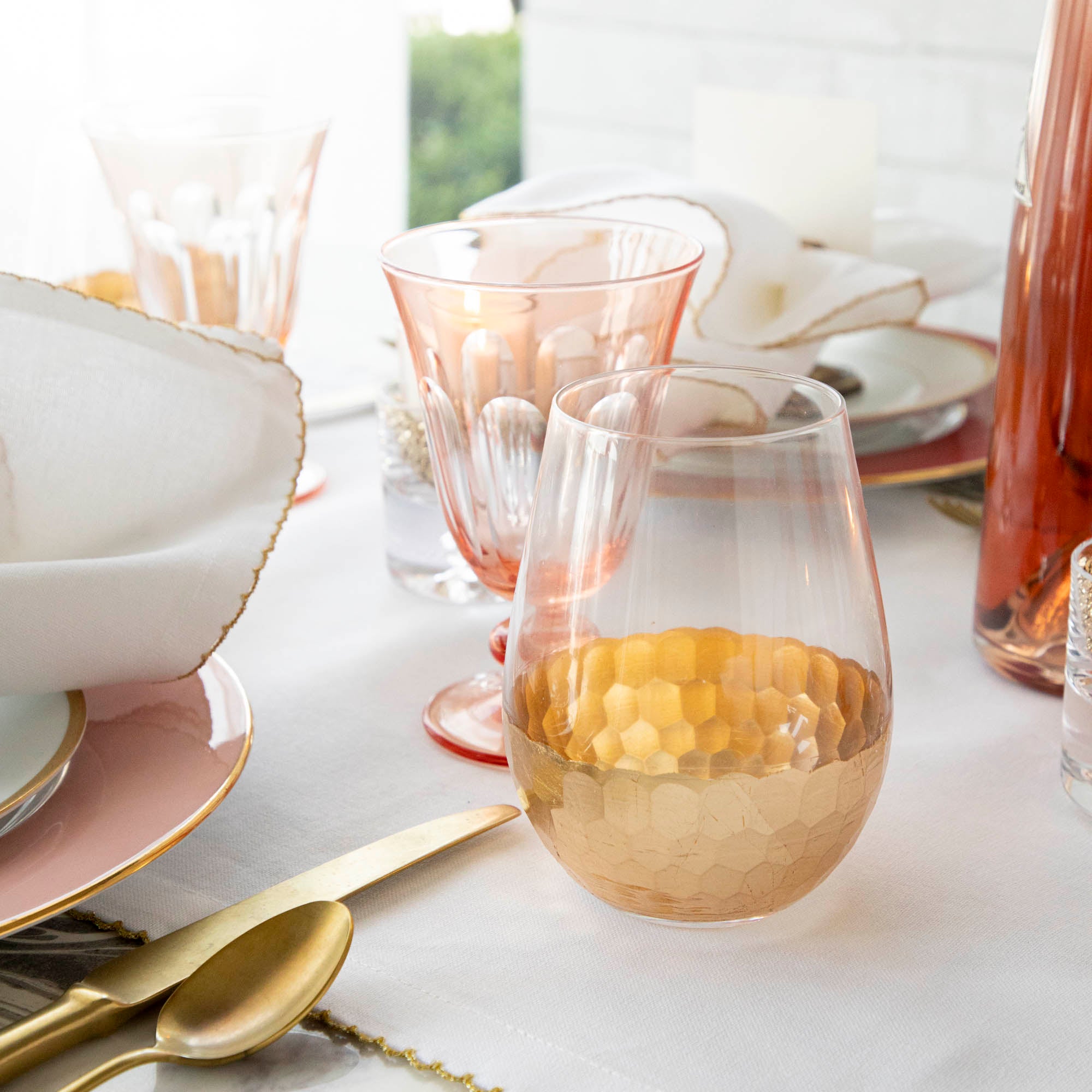 A table setting with Vitorrio Stemless Glassware plates, and napkins.