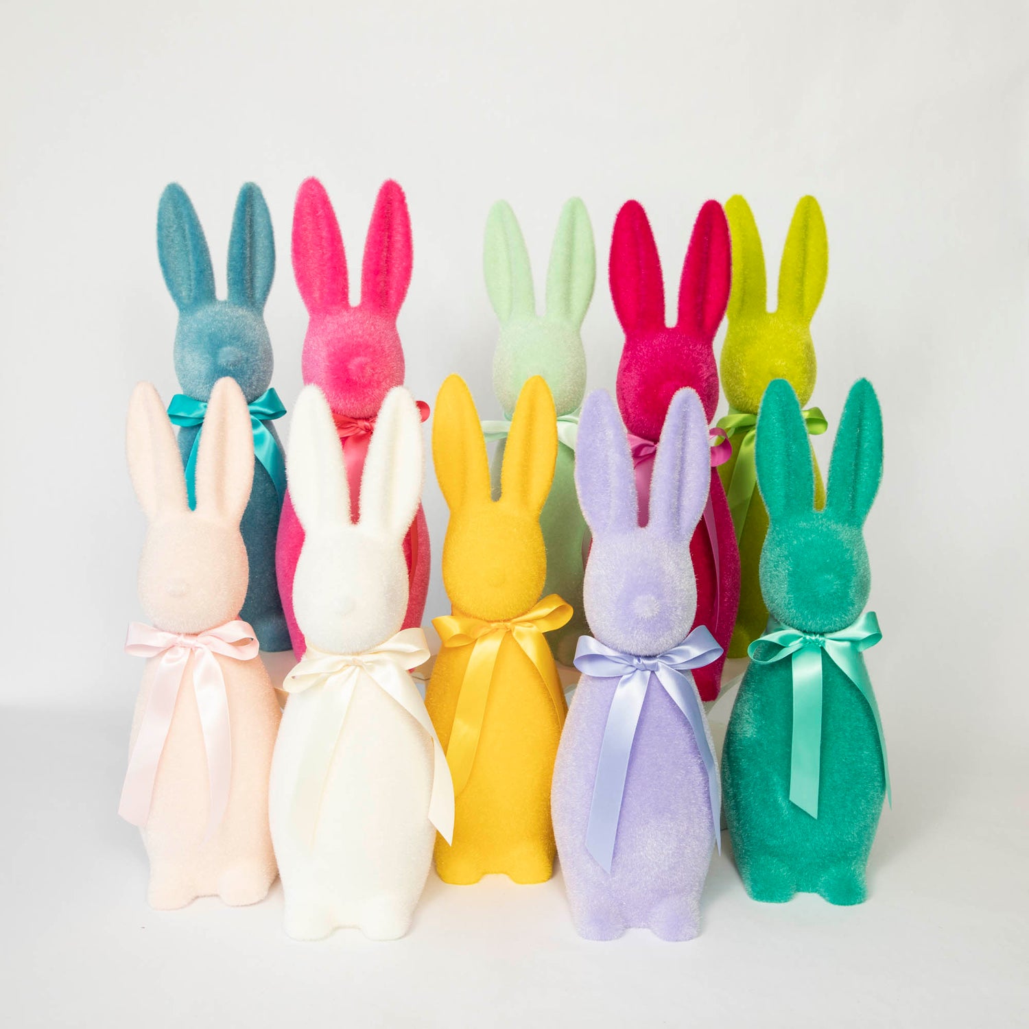 A group of Glitterville Medium Flocked Button Nose Bunny rabbits, perfect for an Easter celebration and as a special gift.