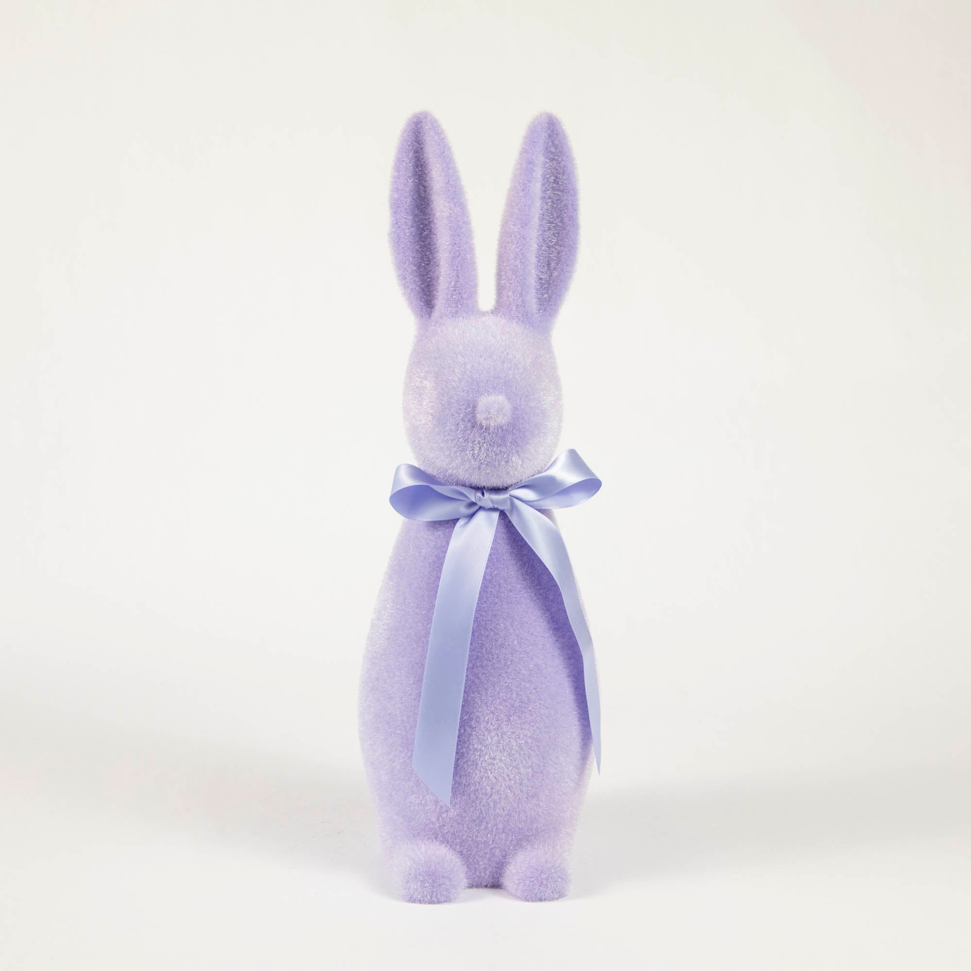 A Medium Flocked Button Nose Bunny, perfect for an Easter celebration gift, wearing a blue bow from Glitterville.